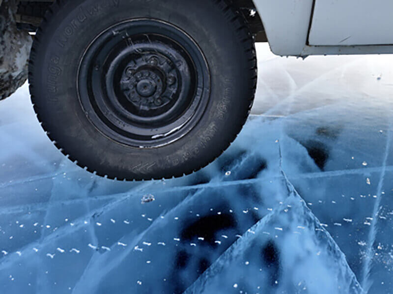 колесо машины на прозрачном льду